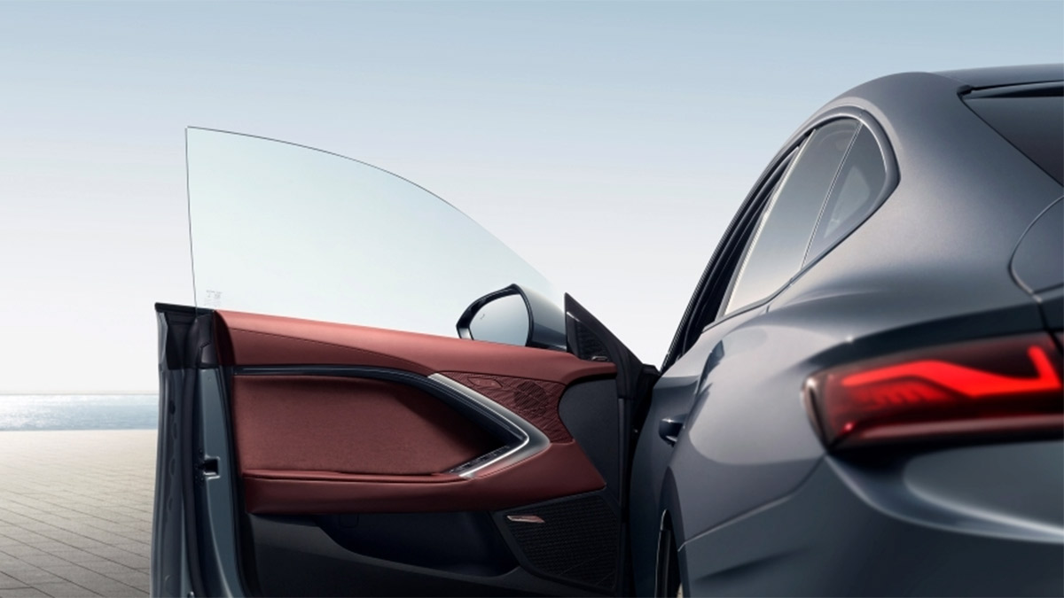 Left-hand door of grey MG7 open showing red trim and frameless window.