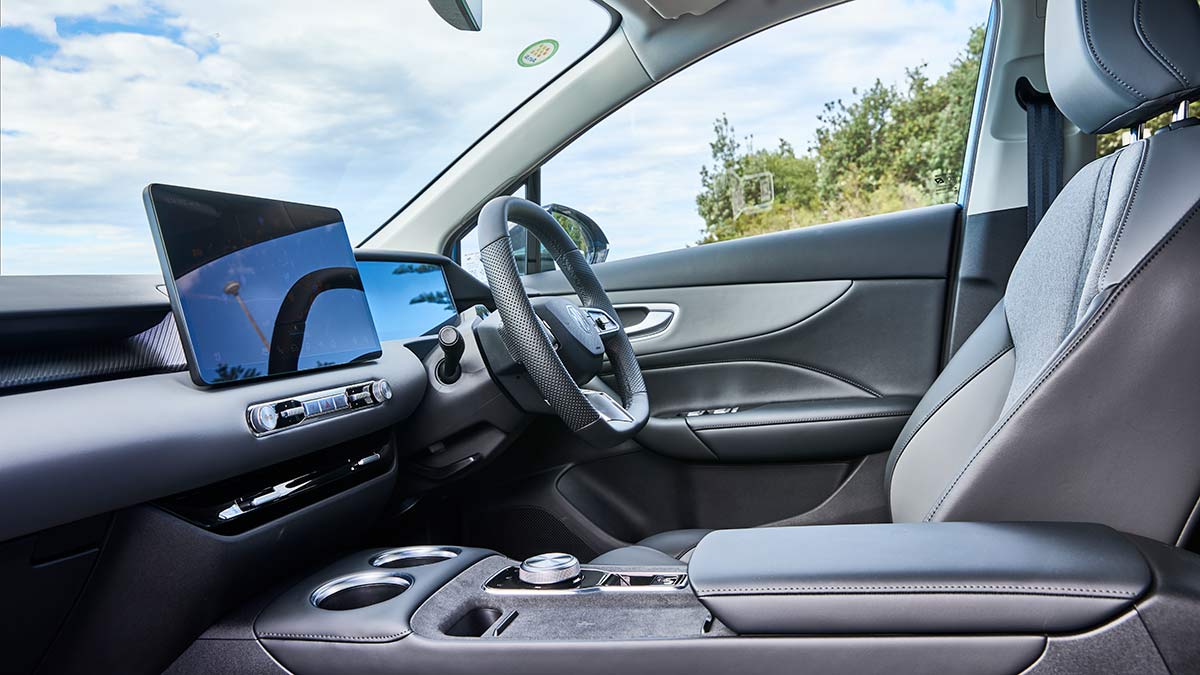 Low-angle view of driver's area in MG4 electric hatchback with light grey trim and twin digital screens.