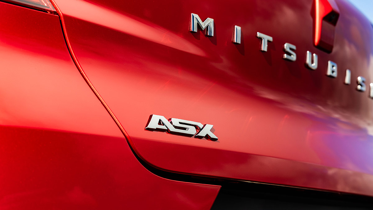 Chrome ASX badge and Mitsubishi lettering on tailgate of red 2026 Mitsubishi ASX small SUV.
