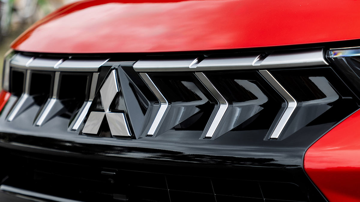 Close-up of Mitsubishi ASX grille with 3D silver fillets and prominent triple-diamond badge.