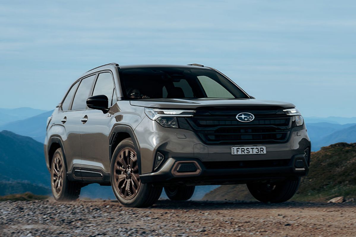 Olive green Subaru Forester Hybrid medium SUV on rocky off-road trail in Australian high country.