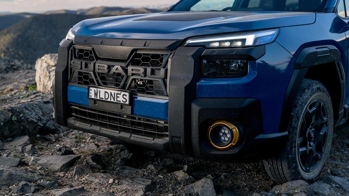 Frontal shot of blue Subaru Outback Wilderness parked on rocky off-road trail in Australian high country.