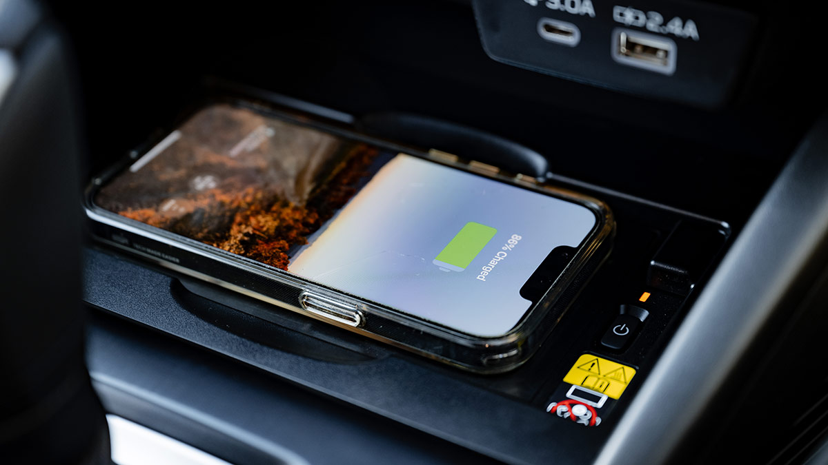 Mobile phone on new centre console wireless charging pad in Subaru Outback SUV.