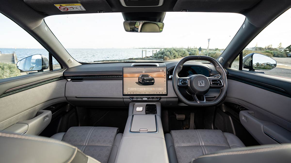 Front seat area of Zeekr 7X electric SUV with large touchscreen, two-tone grey interior trim, ambient lighting strip and large centre console.