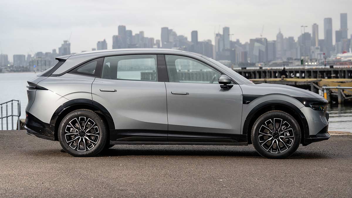 Side profile view of metallic grey Zeekr 7X medium electric SUV parked at waterfront at Williamstown with Melbourne CBD behind.