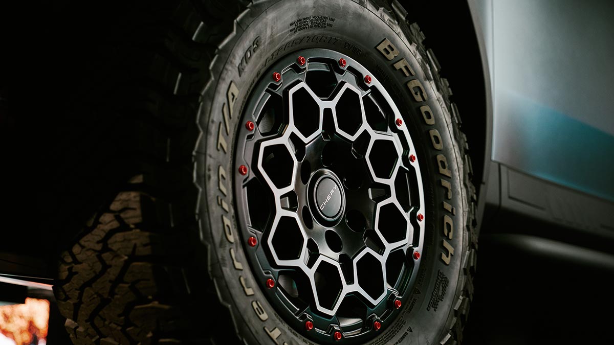 Geometric alloy wheel design with red studs and off-road tyres on Chery KP31 dual cab ute prototype.