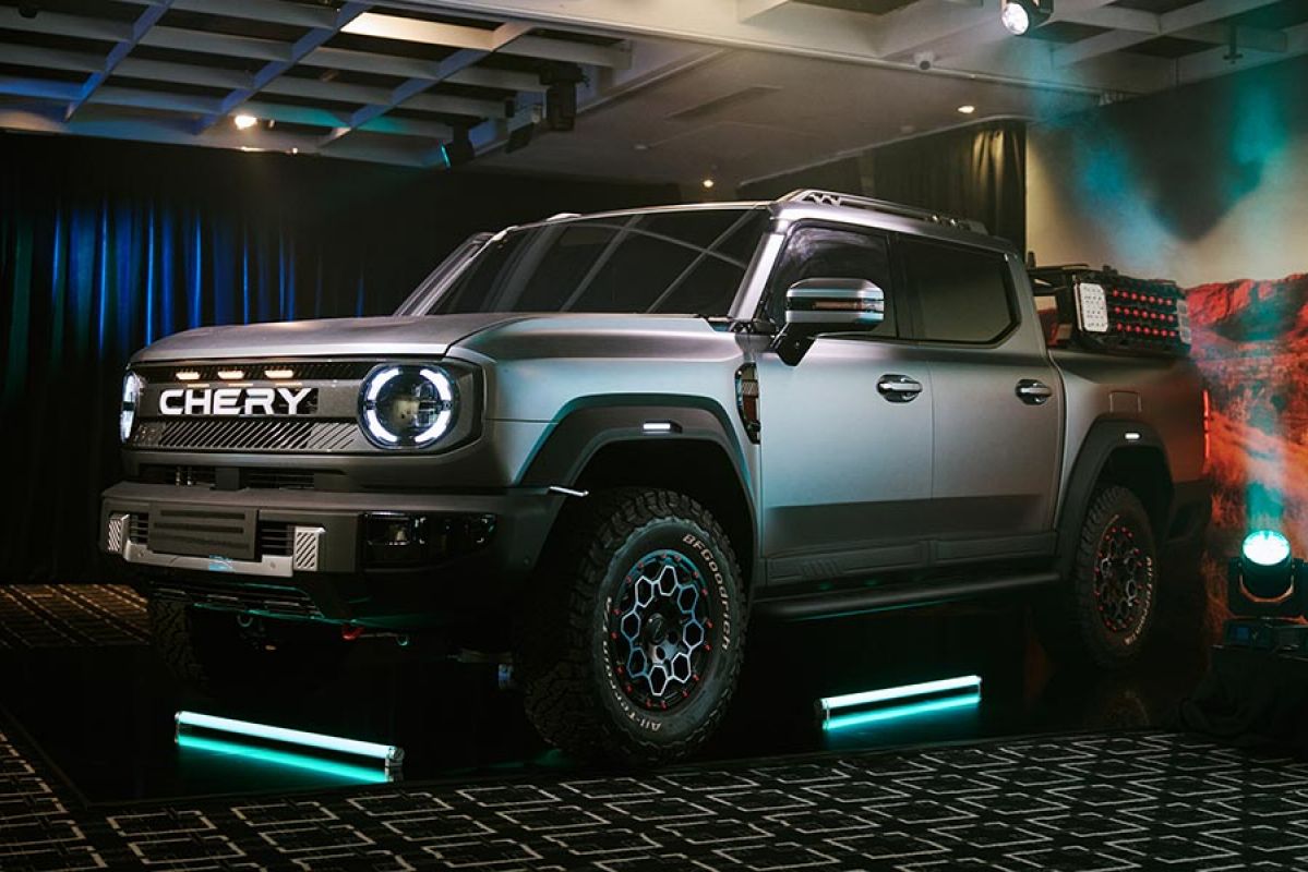 Silver design prototype of Chery KP31 ute at Sydney venue with green fluoro floor lights and Australian outback imagery behind.