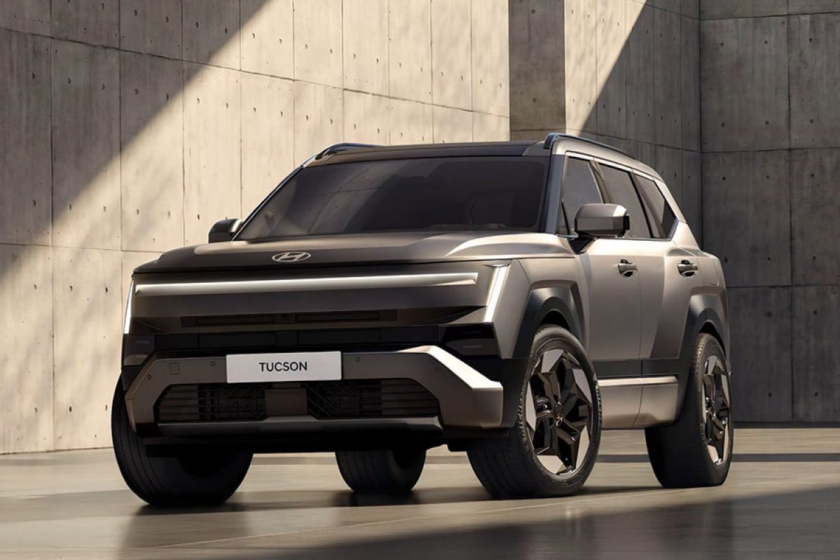 Grey metallic Hyundai Tucson SUV surrounded by large concrete walls with shafts of light across vehicle and building.