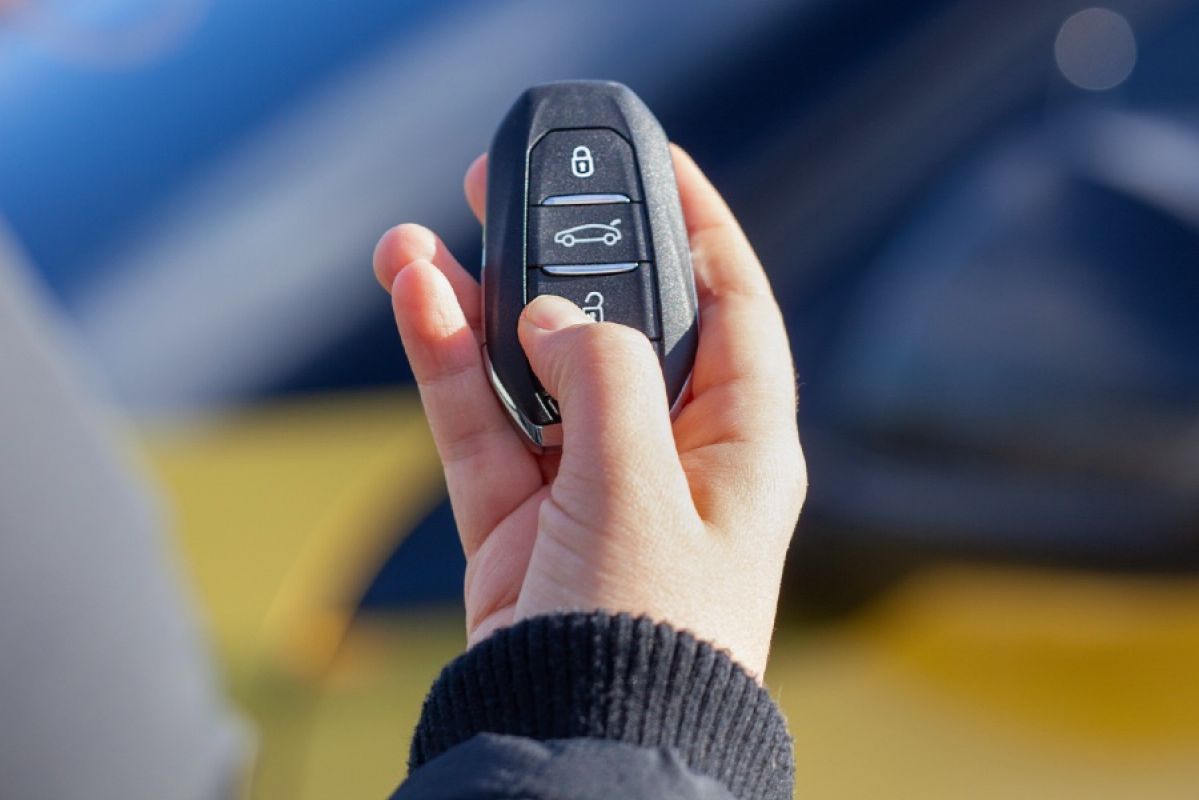 person unlocking car with remote key