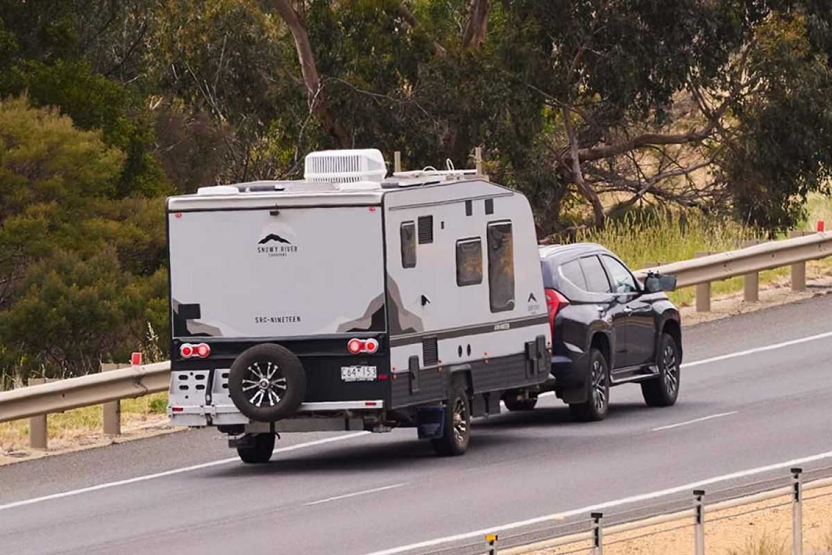 Black large SUV towing a caravan on Western Highway in Victoria