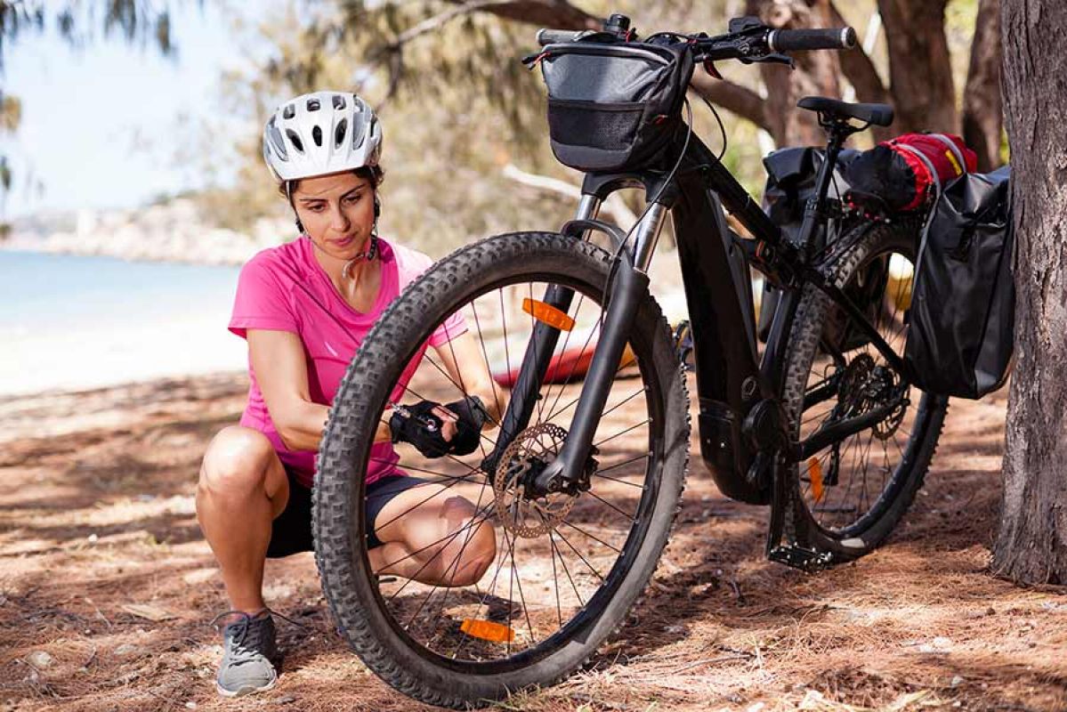 Woman kneeling down at front wheel of electric bike