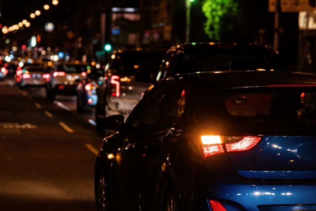 A busy road filled with cars in inner city Melbourne at night