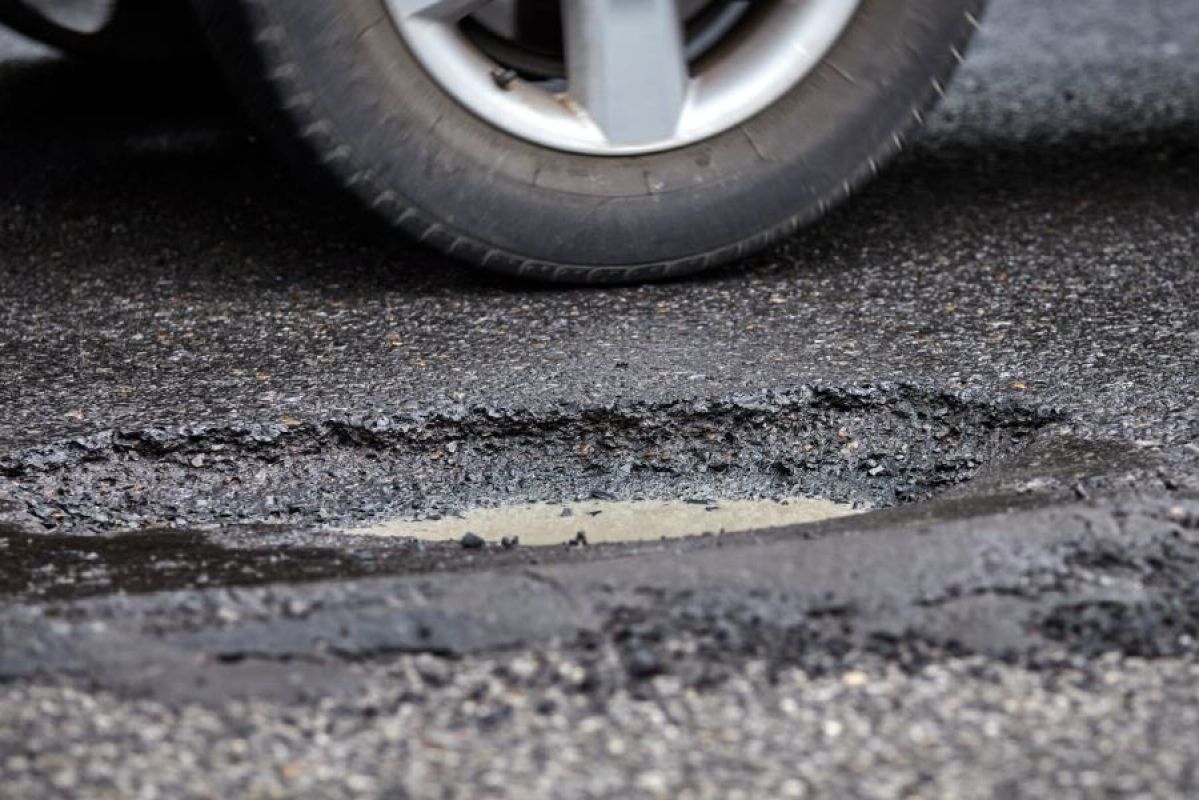 car tyre near pothole in road