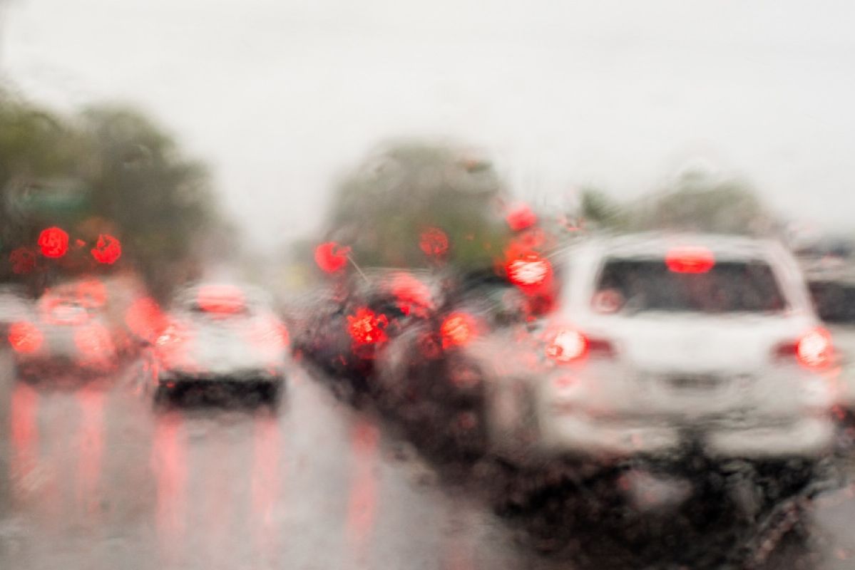 view through a car windscreen to a rainy road full of traffic