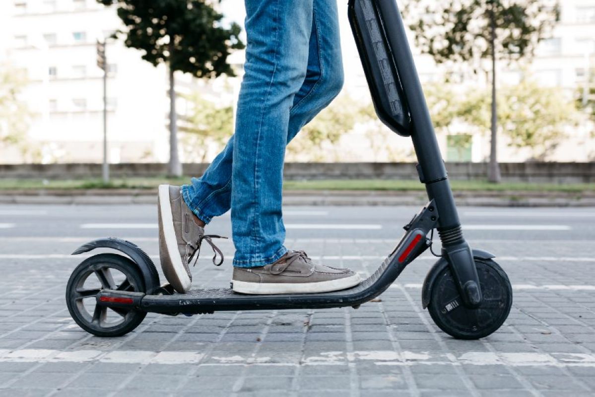 young man riding an e-scooter outside