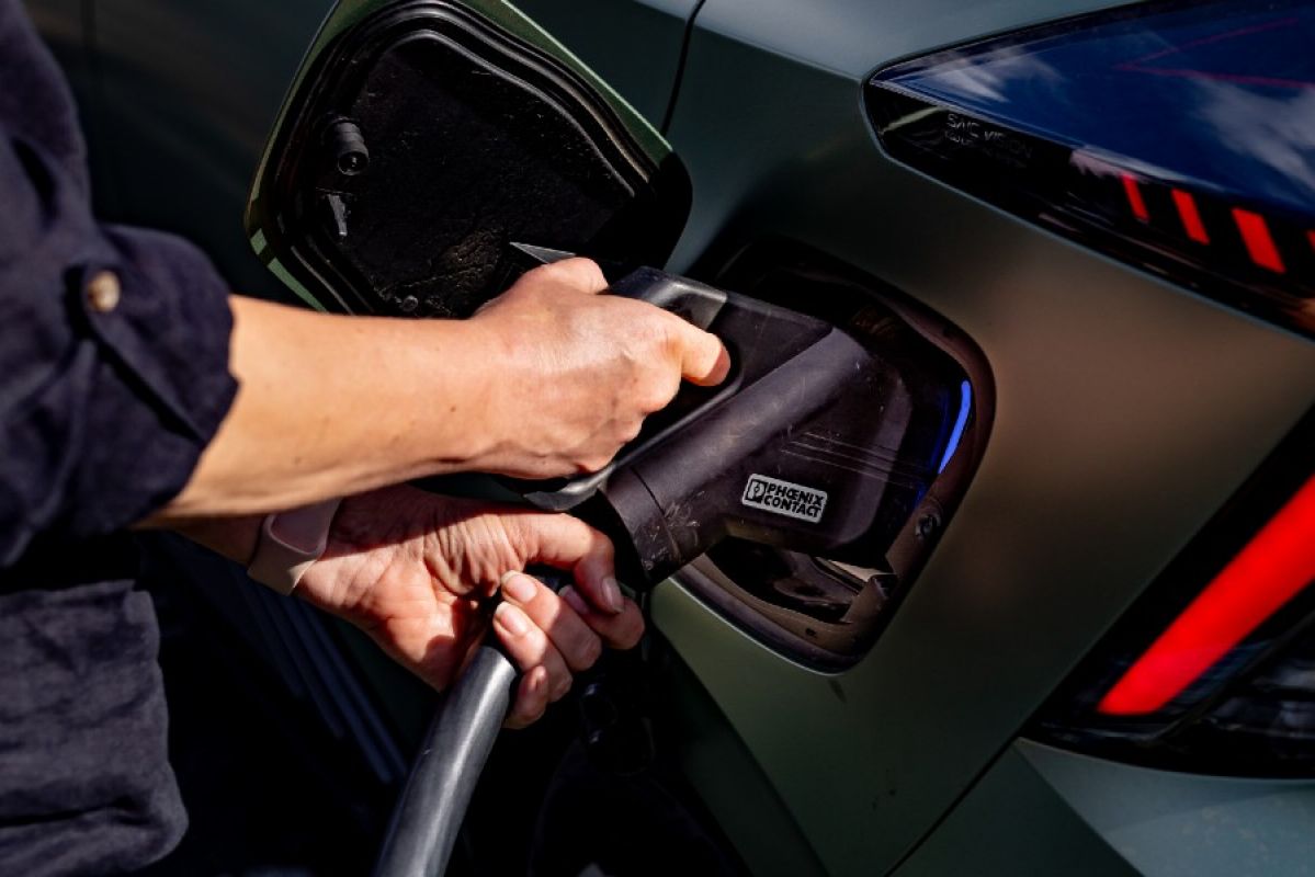 A person plugging a charger into a green MG4 Xpower