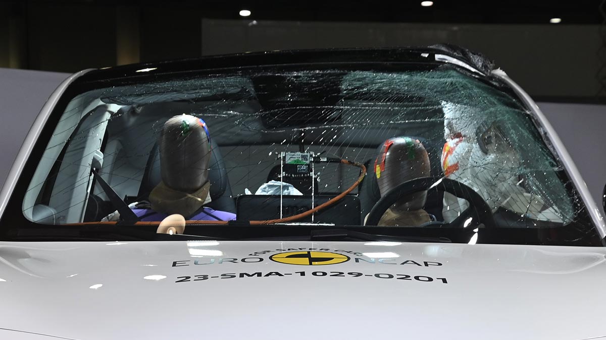 Close-up of crash test dummies hitting airbags in side impact test with white Smart 3 EV.