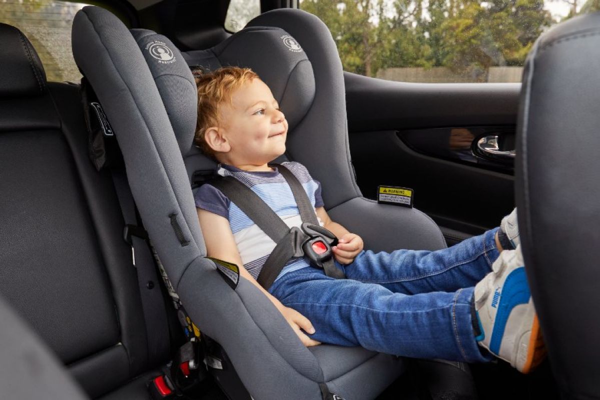 A toddler sitting in a forward-facing child car seat