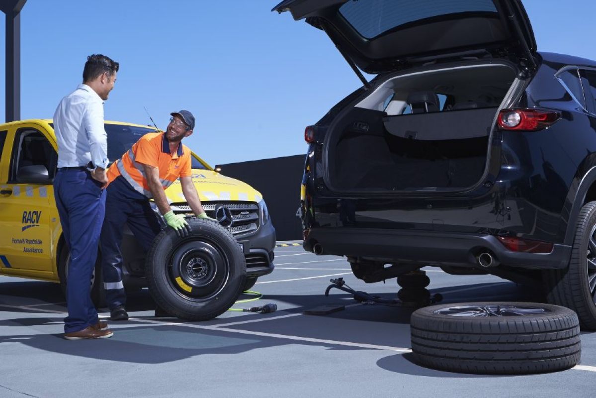 RACV ERA worker helps man change tyre on his SUV