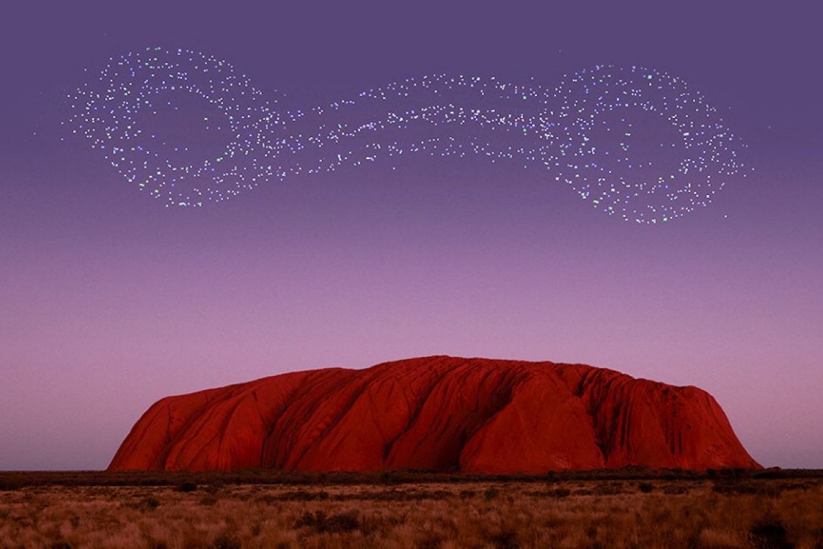 Uluru at sunset with a drone show in the sky