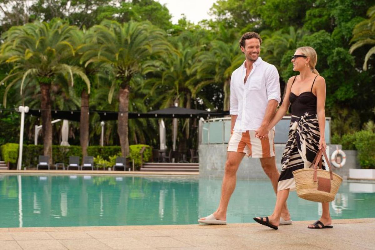 A couple  hand in hand near a pool at RACV Gold Coast Resort