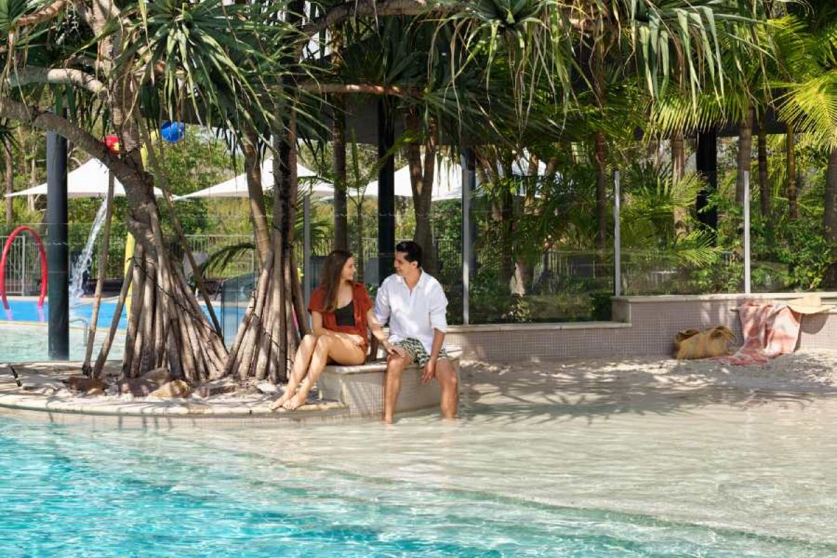 couple lounging by RACV Noosa Resort's pool
