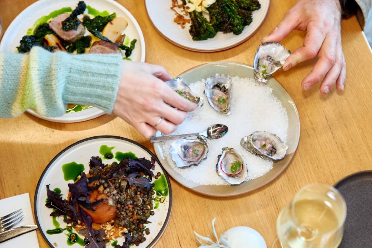 two people eating oysters at a restaurant
