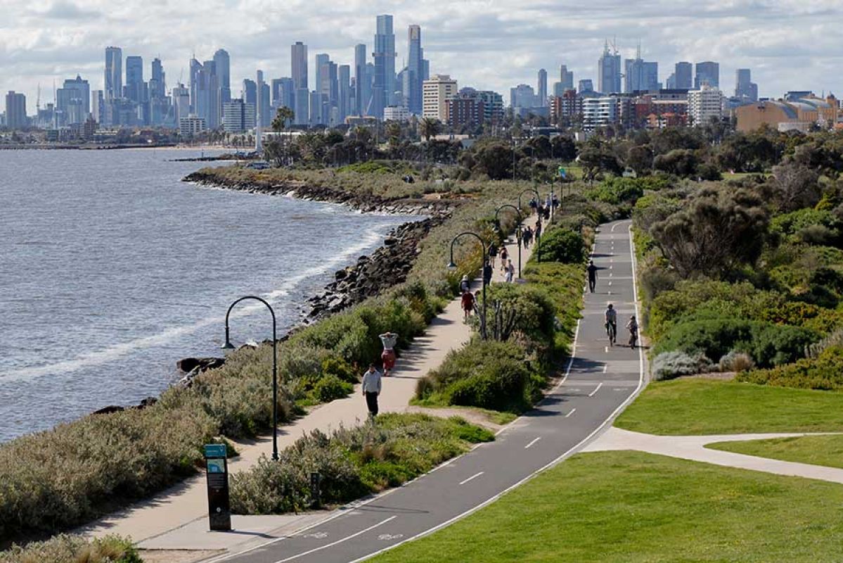 View from Point Ormond in Elwood showing Port Phillip Bay, pedestrians and cyclists on coastal paths with Melbourne city skyline behind