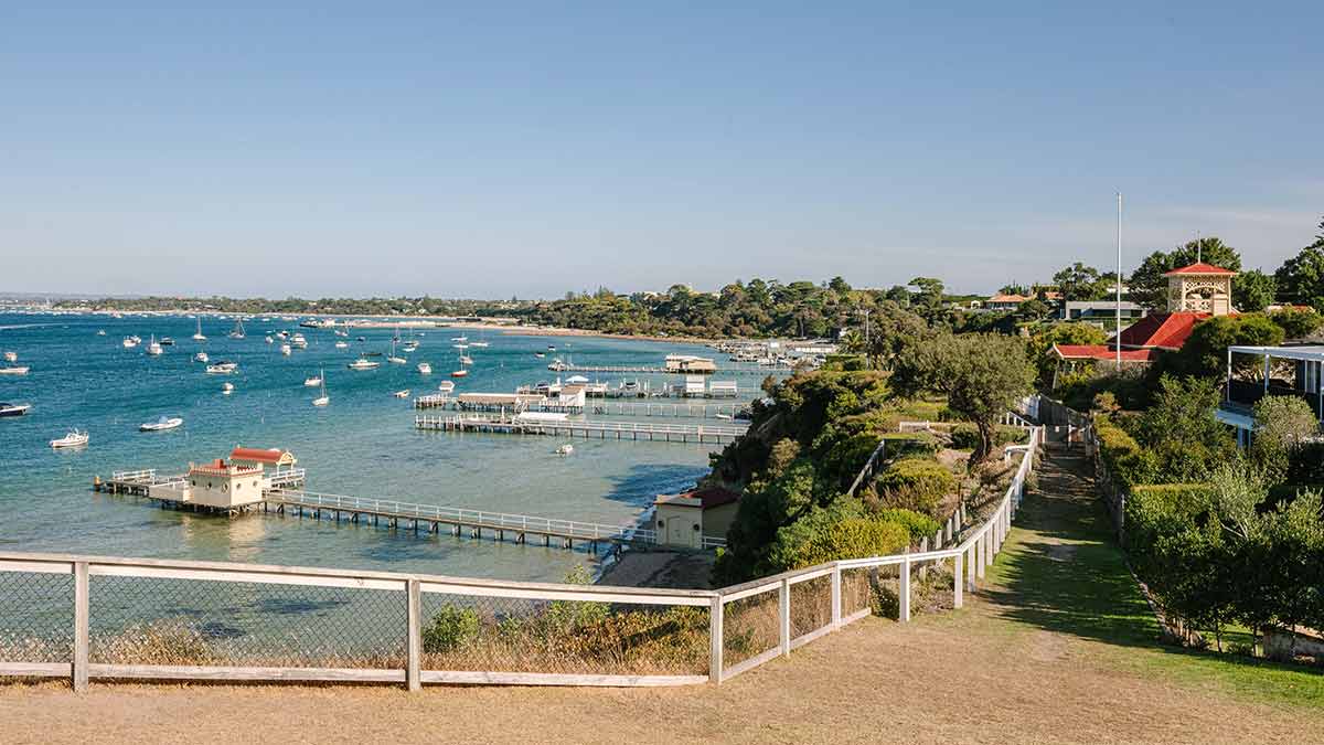 View of Millionaire's Walk at Sorrento with grand houses overlooking jetties and boats and yachts on Port Phillip Bay