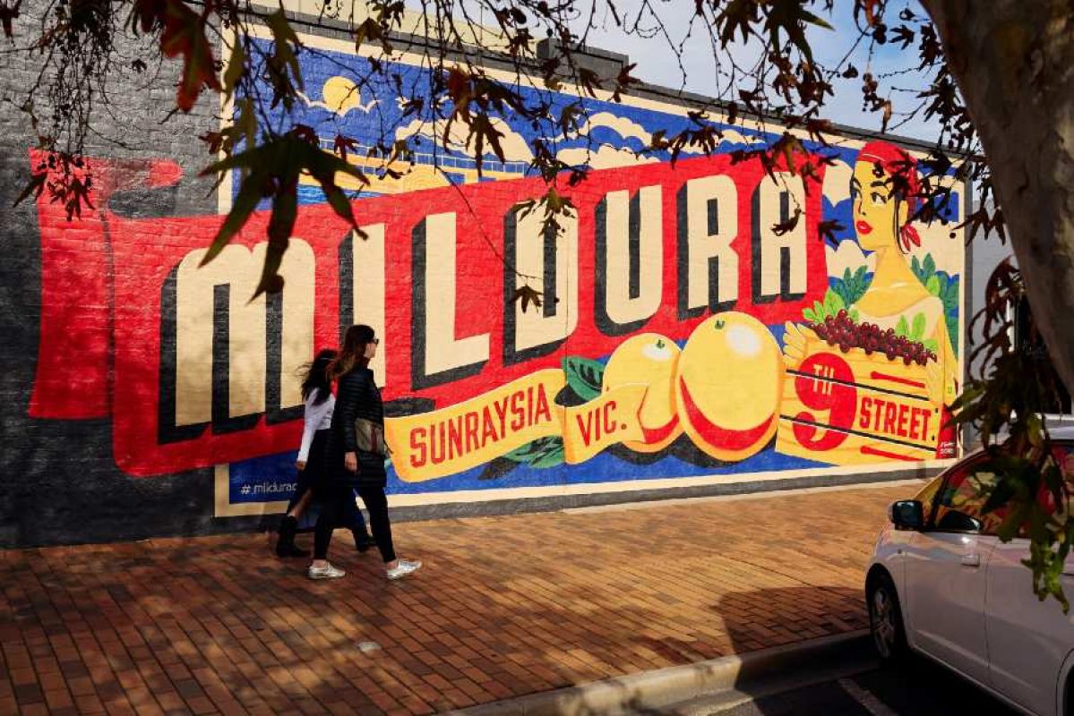 two women walking past the Mildura Sunraysia mural