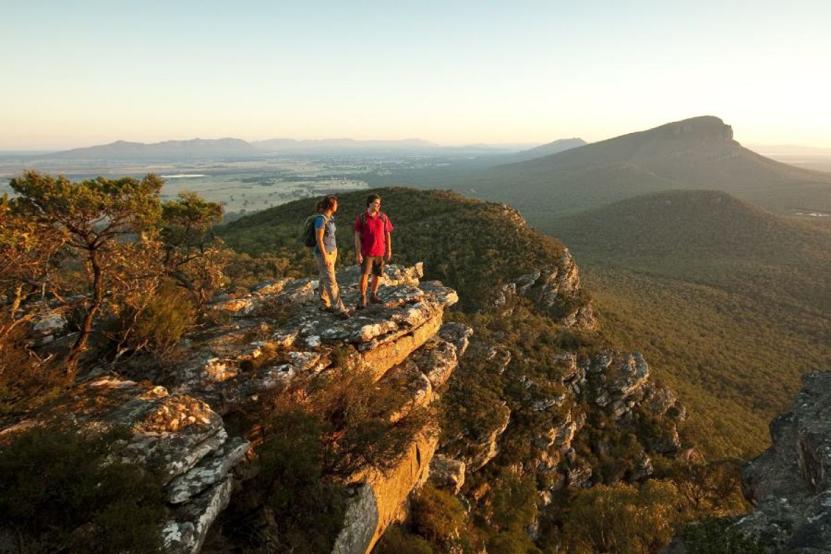 couple standing on rocky lookout in mountains
