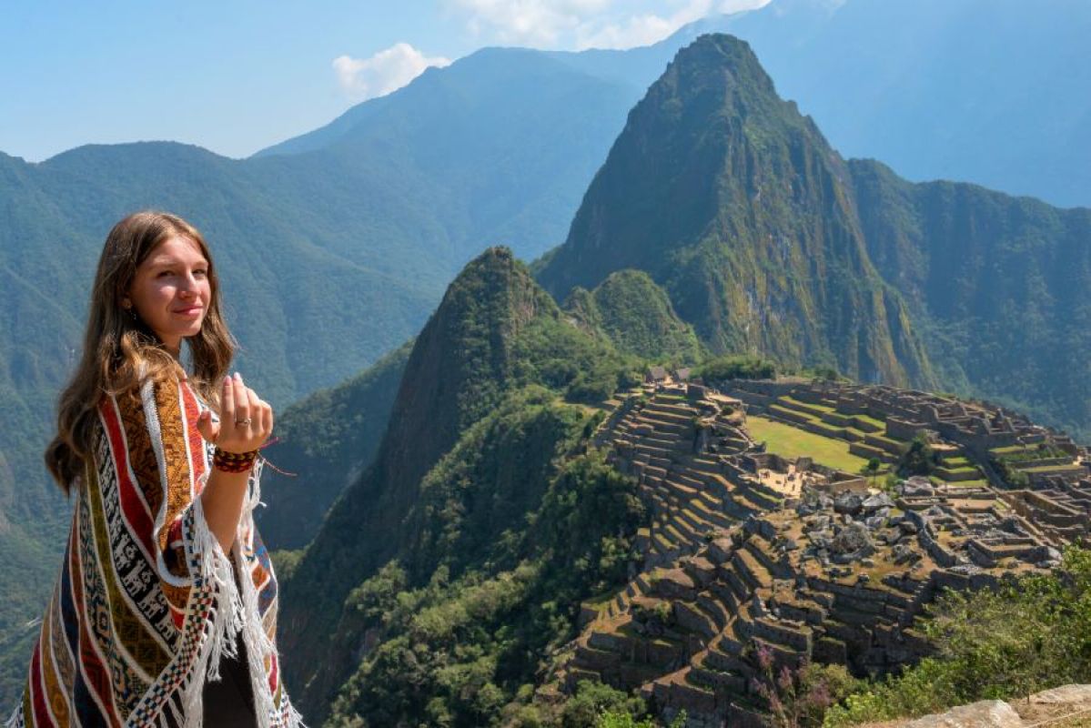 young woman wearing shawl with Machu Picchu in background