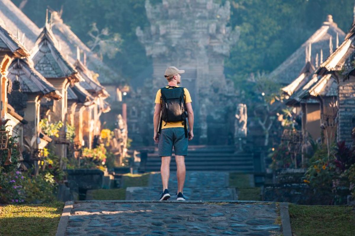 young male tourist standing on Balinese path beween temples