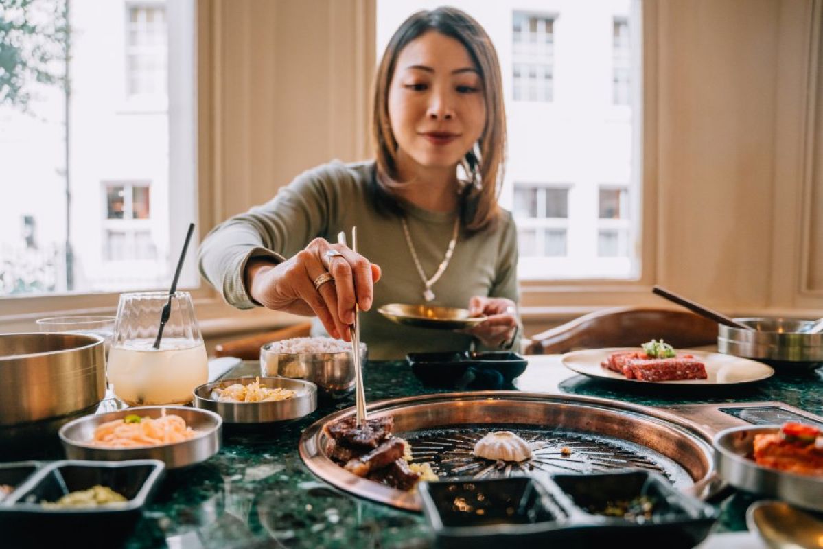 young woman eating Korean barbeque in a restaurant
