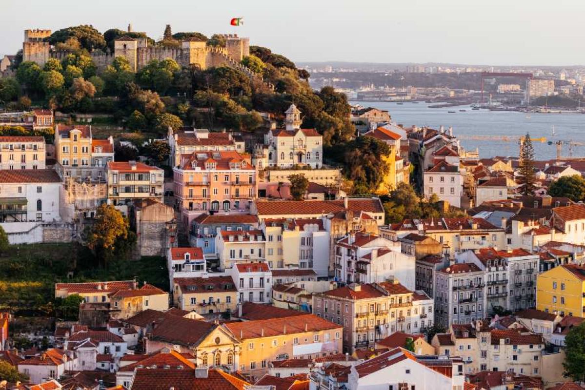 aerial view of Lisbon with castle on hill, river and many buildings