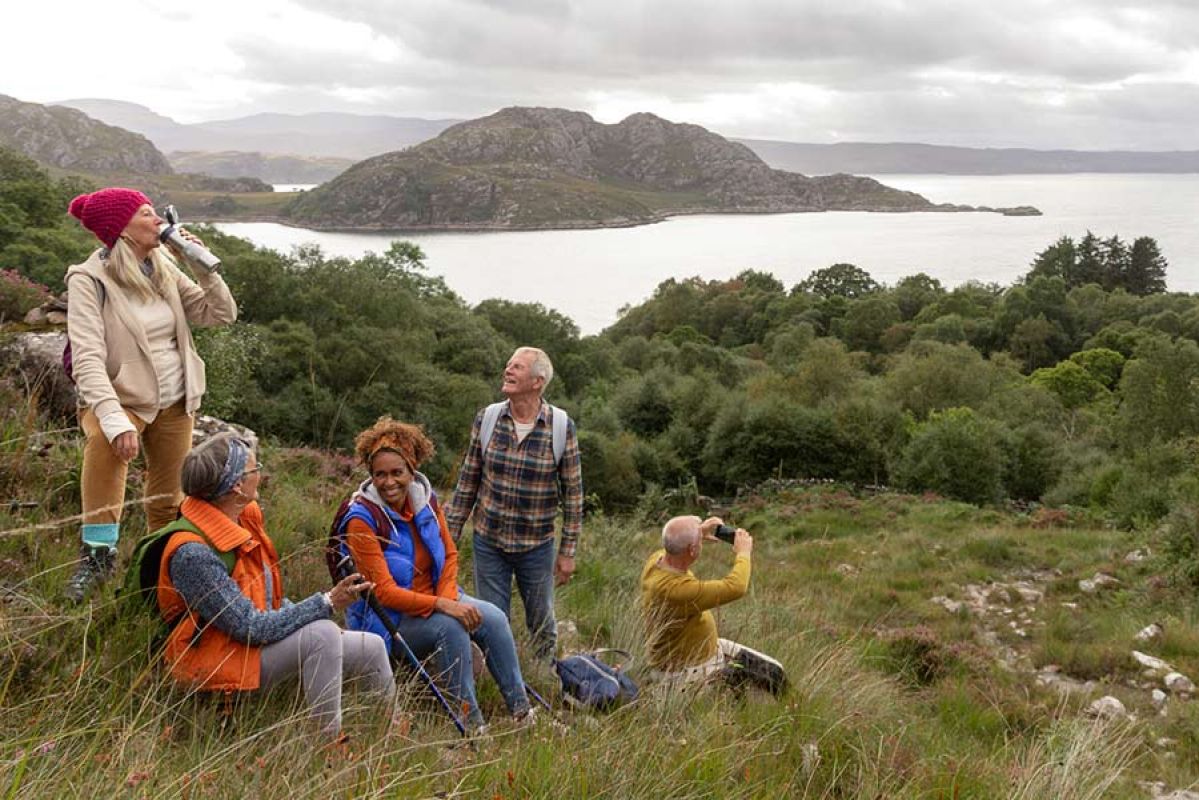 A group of middle-aged hikers stopping for lunch near Loch Torridon in northwest Scotland