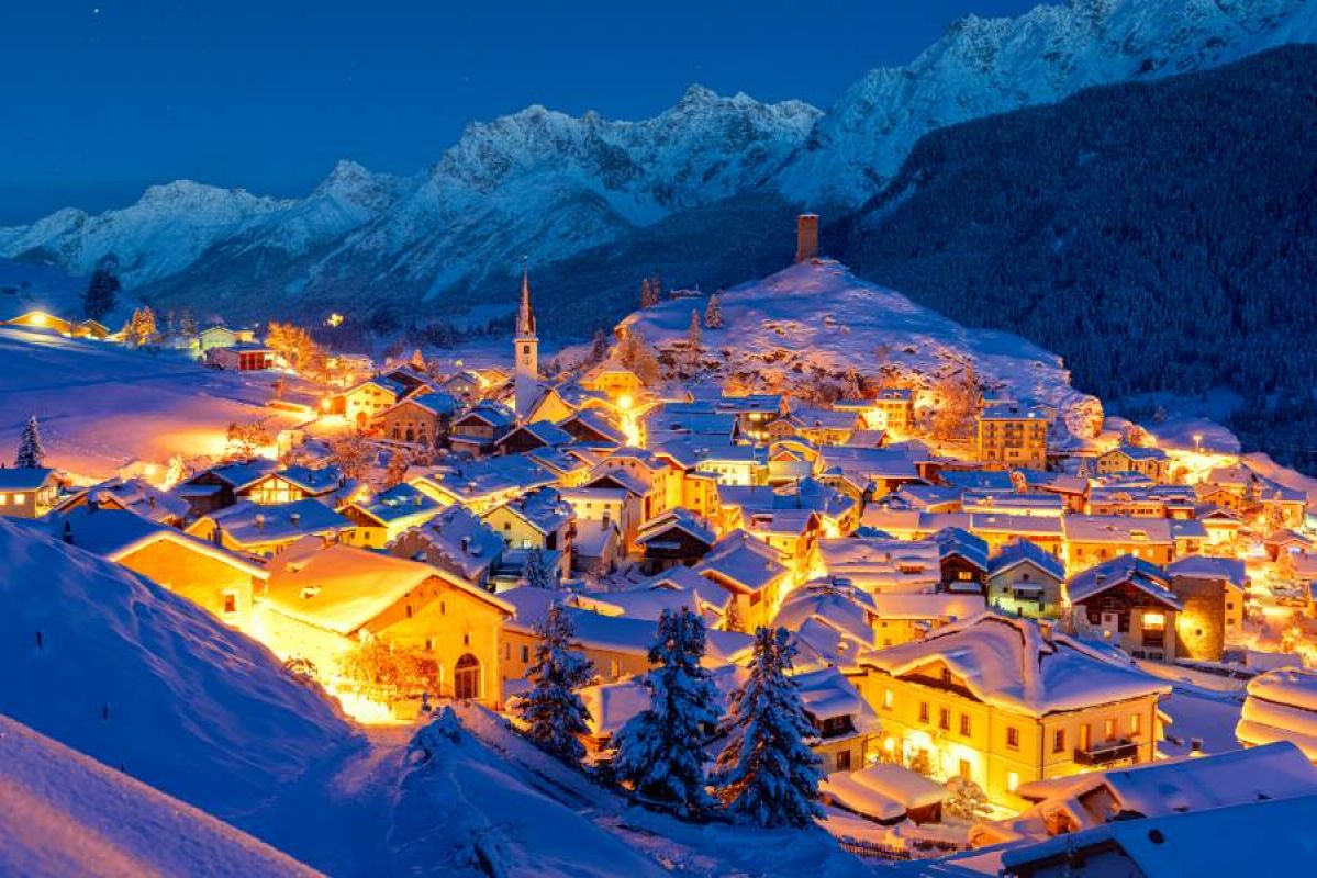 snowy alpine town lit at night
