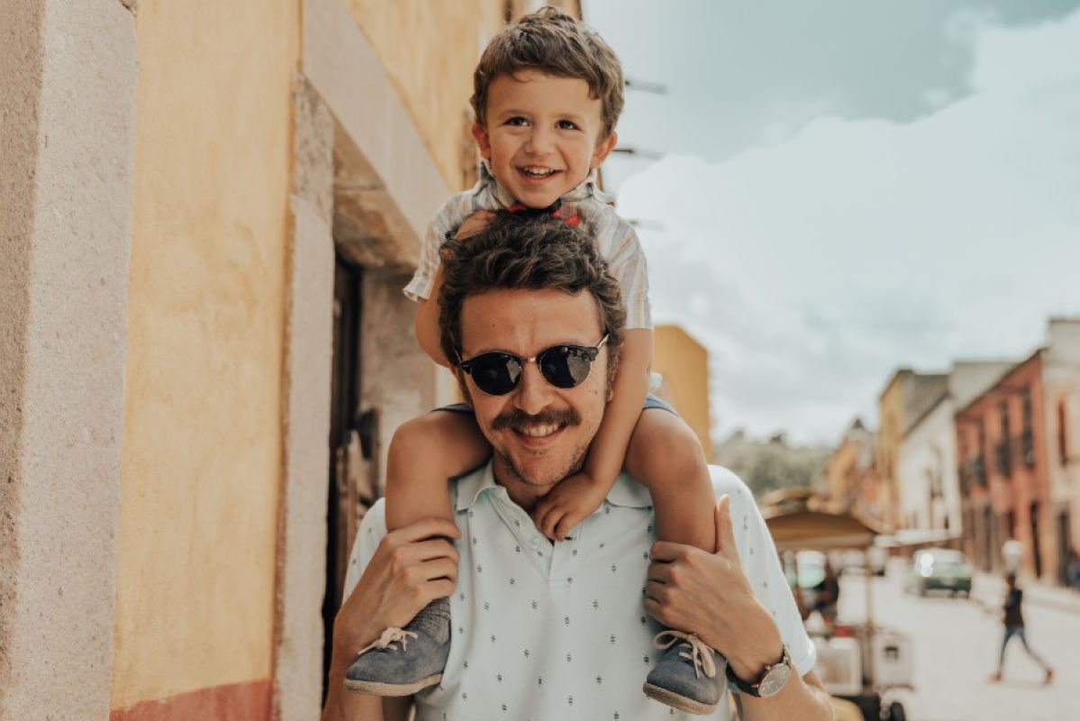 father holding son on his shoulders in overseas city