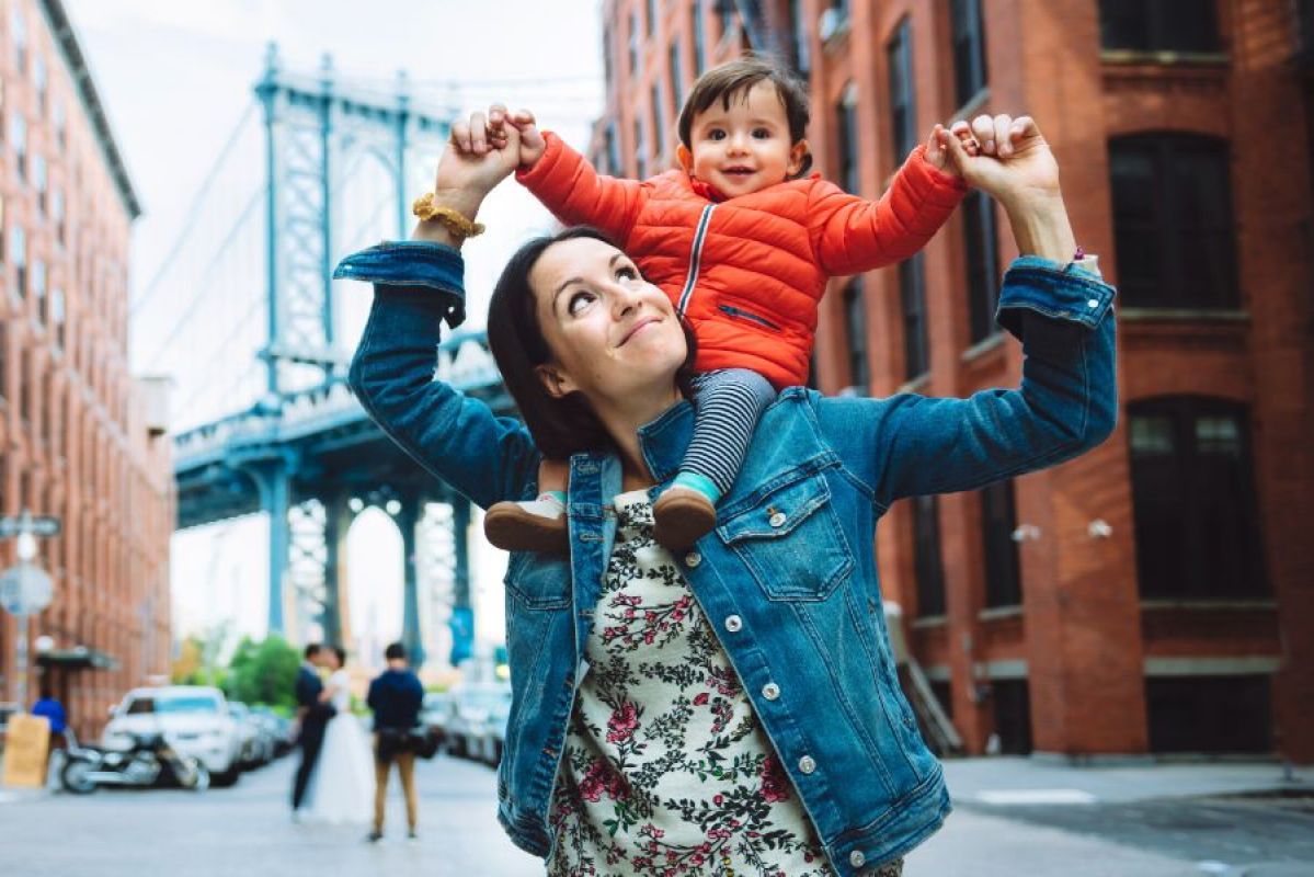 mother with young son on her shoulders smiling in New York City