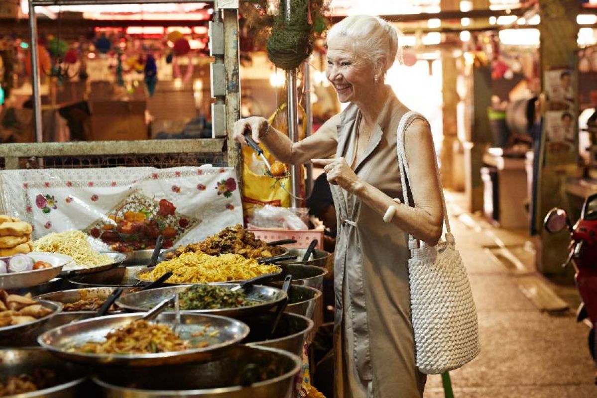 senior woman at a street food market overseas