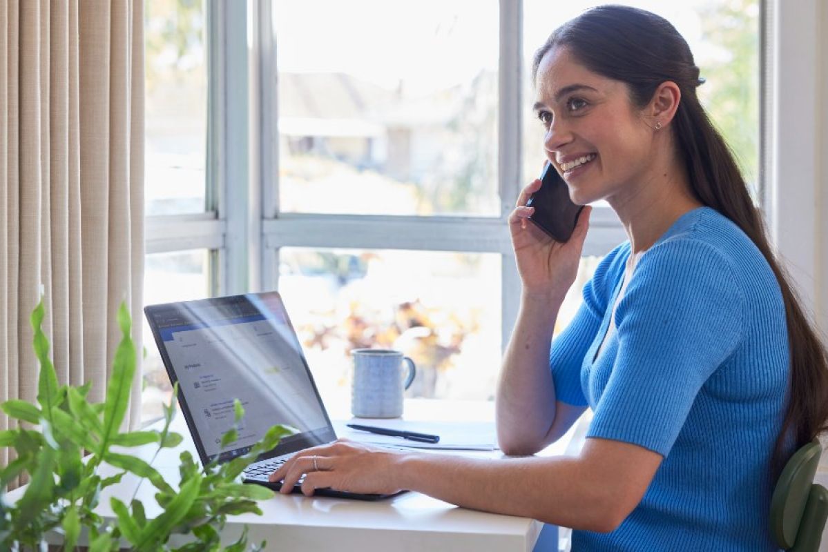 woman making a phone call while on her laptop