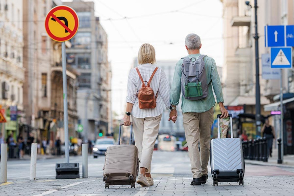 Couple walking down street with suitcases