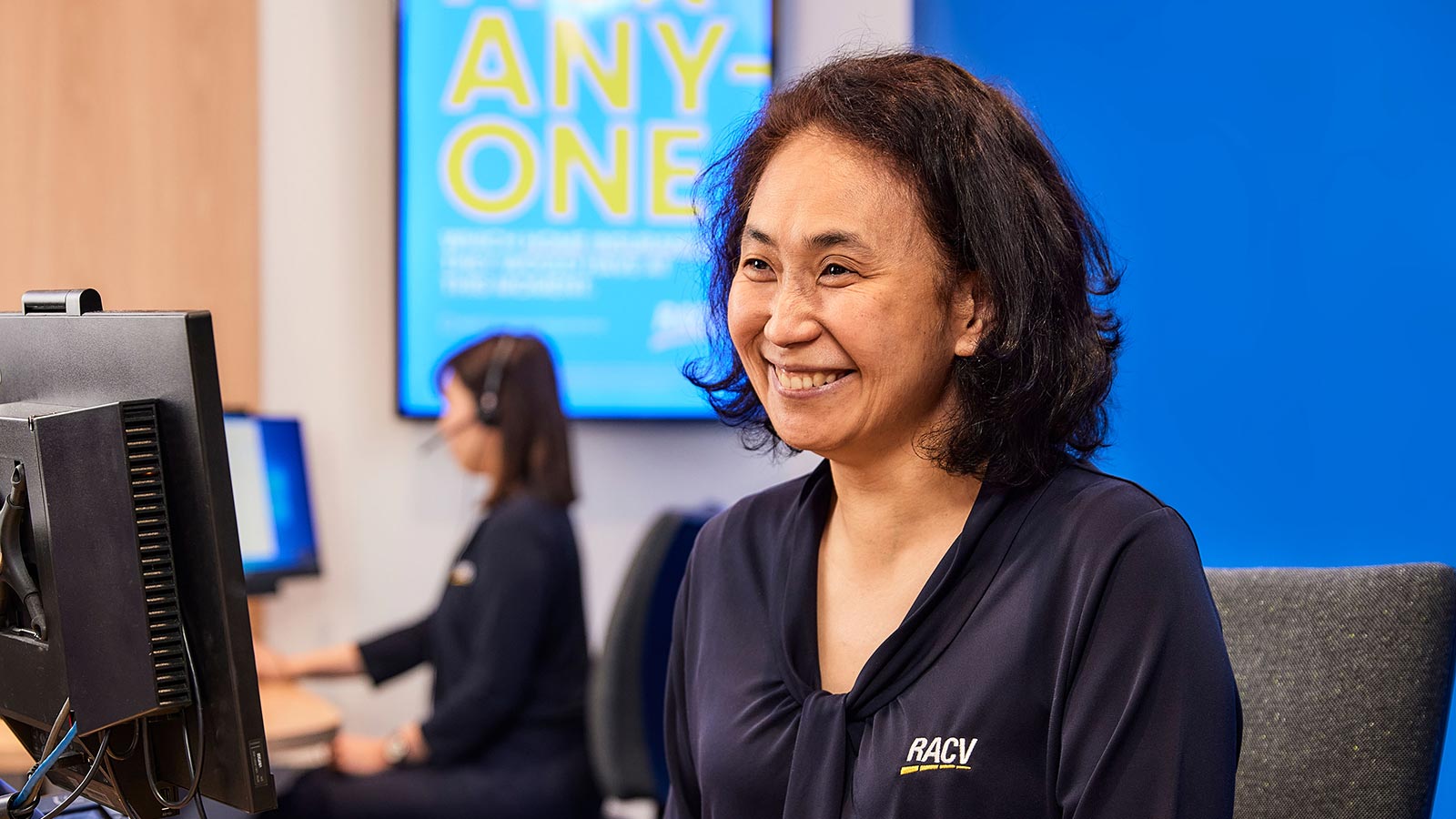 RACV Doncaster staff member smiling at their desk.