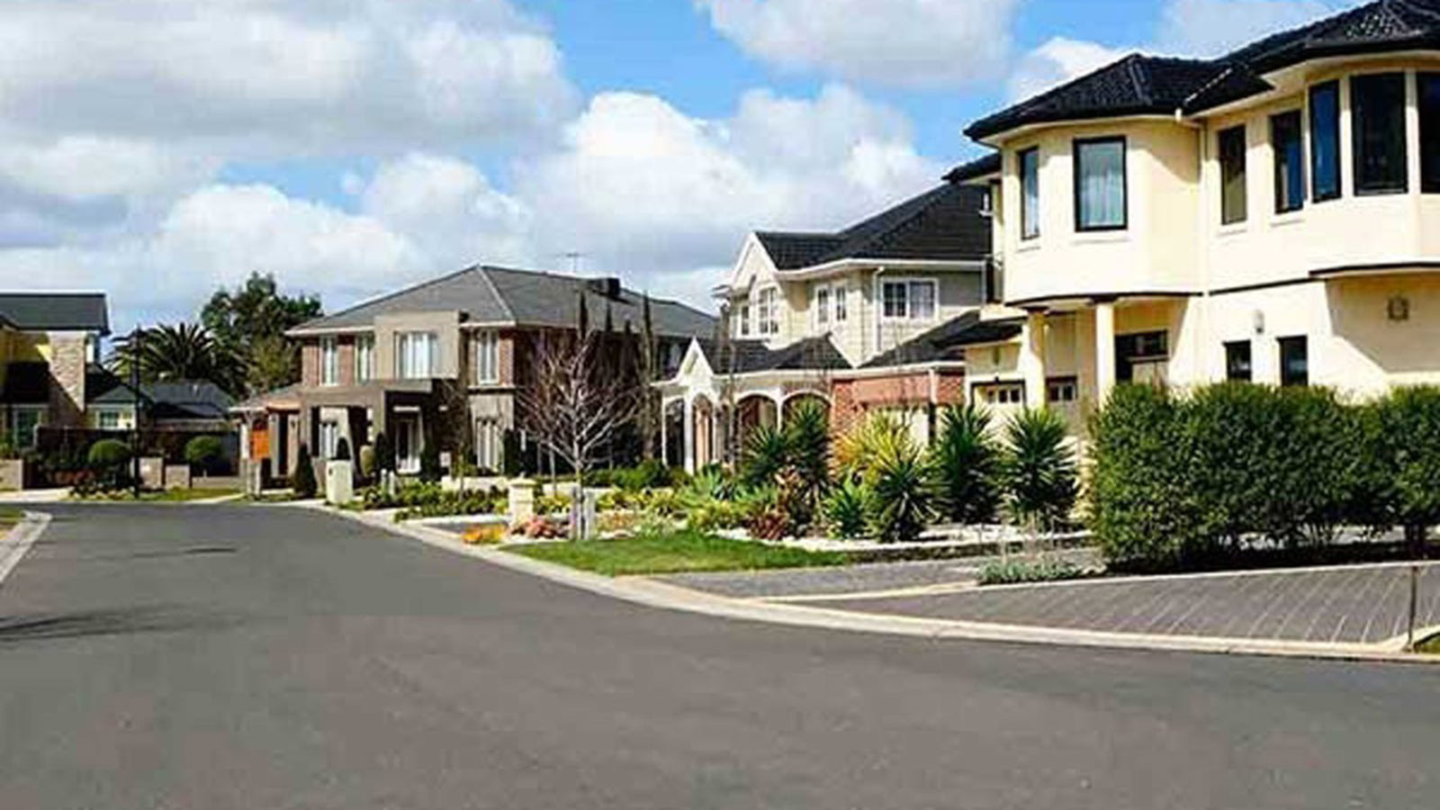 Street and front view of double story houses next to each other.