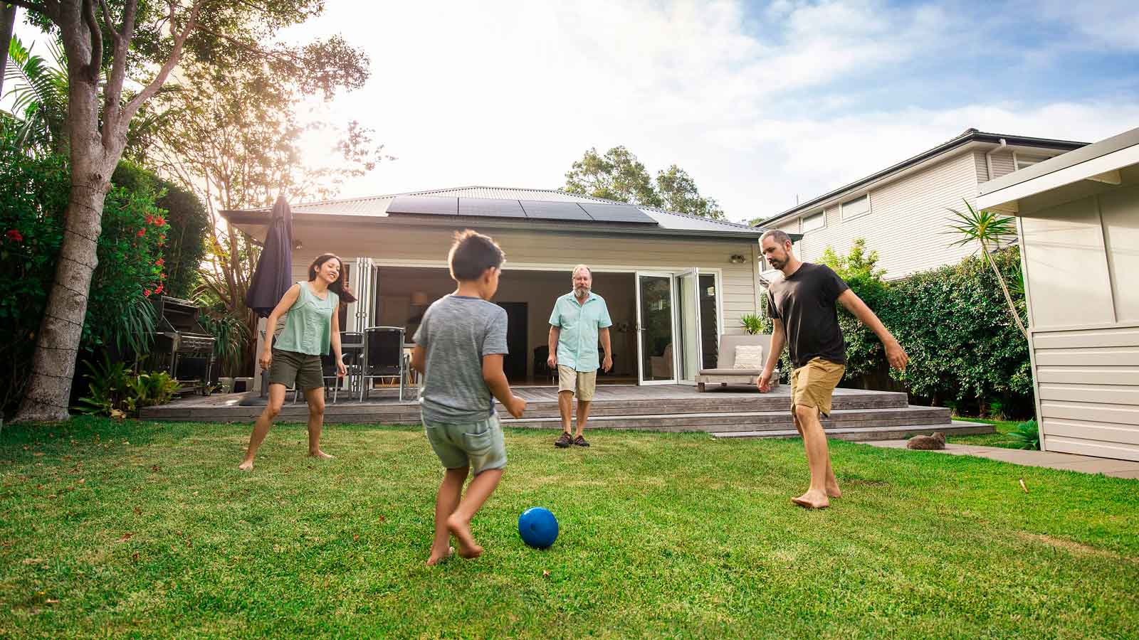 A family enjoying an evening soccer game in their backyard.
