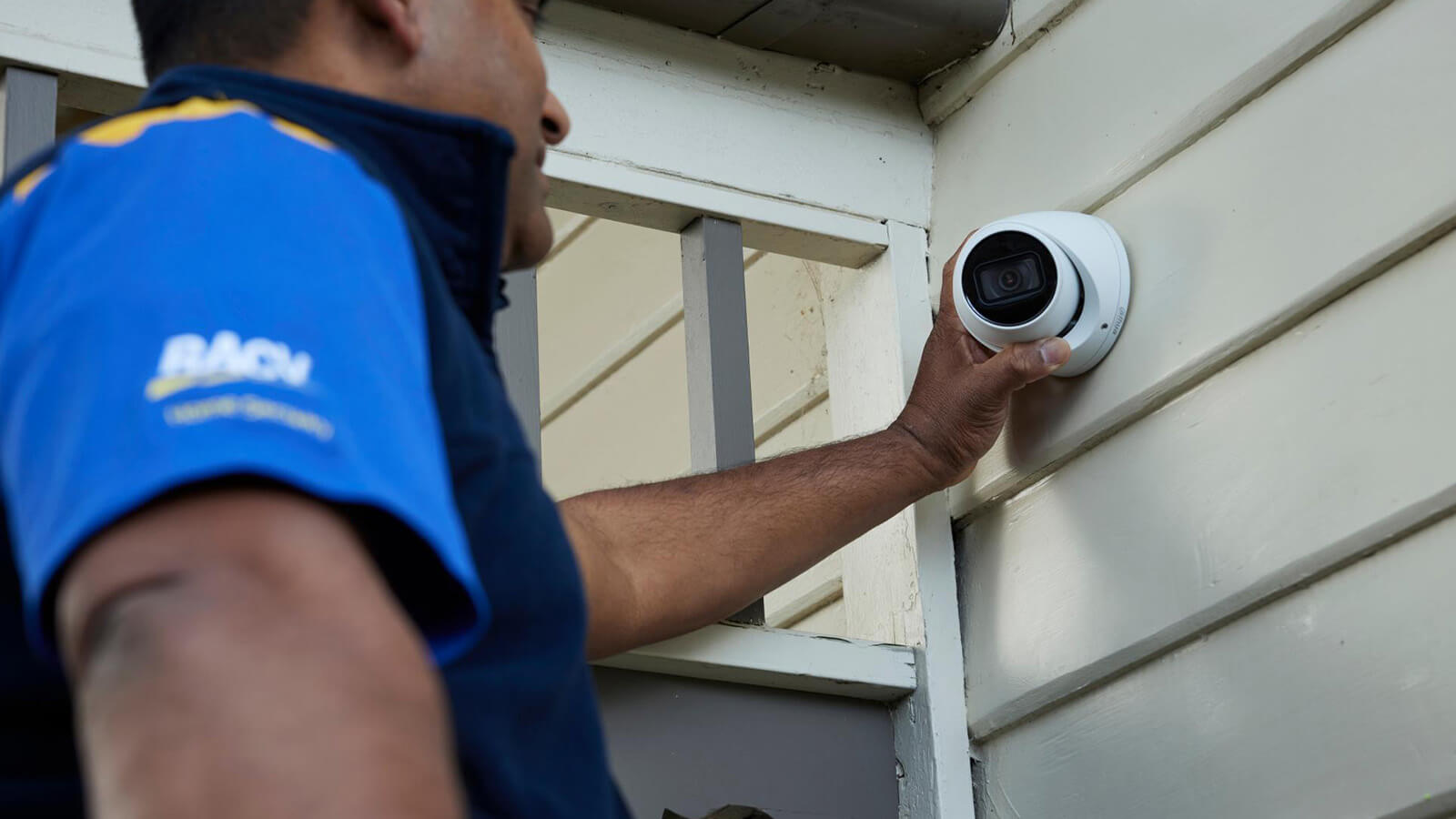 RACV home security technician installing a security camera.