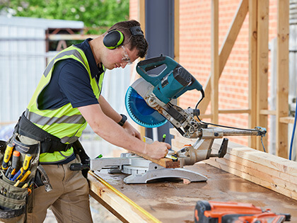 RACV carpenter marking up a piece of wood to saw.