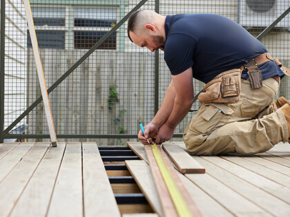 RACV carpenter marking up a piece of timber for a deck.