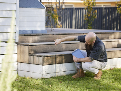 RACV tradesman measuring an outdoor step.