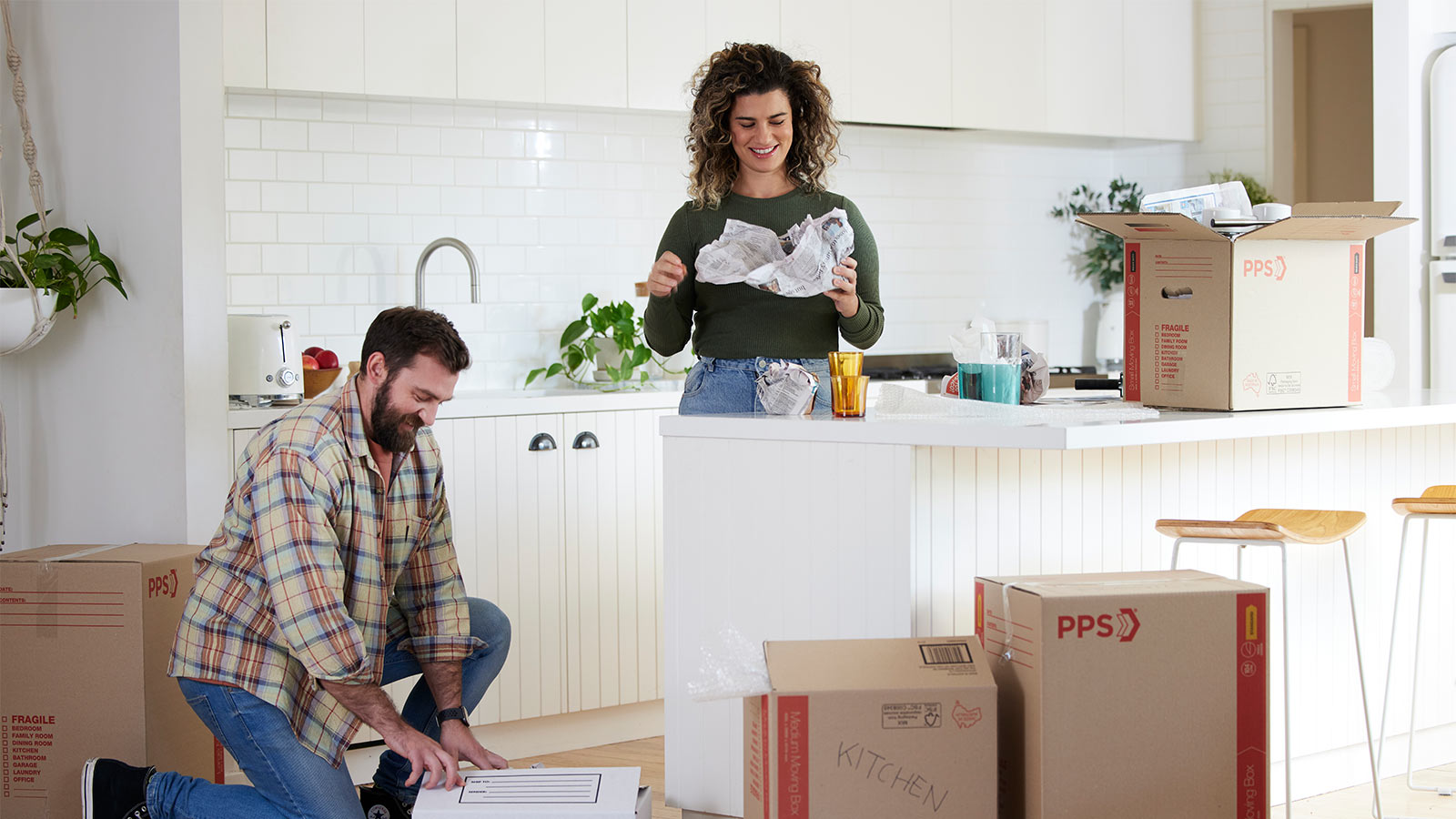 Couple unpacking boxes in their kitchen.